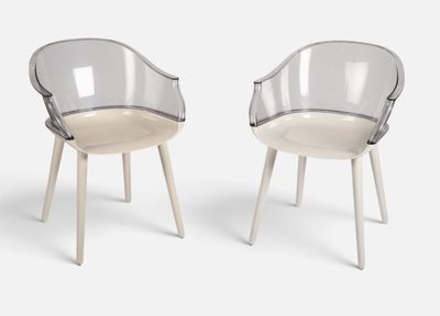 deux chaises en plastique transparent avec des pieds en bois, posées sur une surface blanche