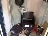 a photo of a hair salon with a chair and a hair dryer