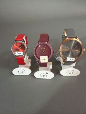 Quatre montres différentes sont exposées dans une vitrine.