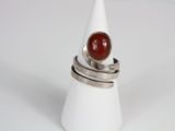 silver ring with a red stone on top of it on a white cone