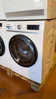 a stack of washing machines on a pallet in a store