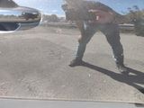 a reflection of a man holding an umbrella on the side of a car