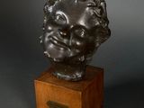 bronze bust of a young boy on a wooden base