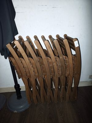 une pile de chaises en bois posée à côté d'une lampe