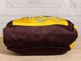 a brown and yellow bag sitting on a wooden table