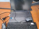 un ordinateur portable posé sur un bureau, avec une souris et un clavier