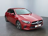 a red mercedes cla is parked in a large room