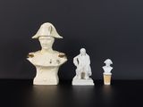 deux bustes d'hommes blancs et une statue d'homme posée sur une table