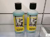 deux bouteilles de liquide posées sur une étagère en verre