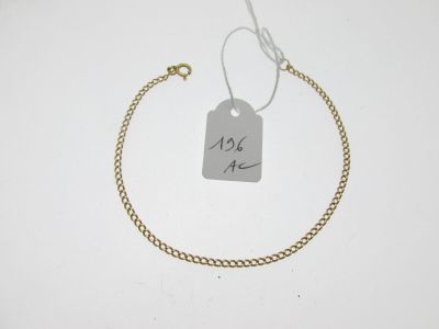 Gros plan sur un bracelet en chaîne en or portant une étiquette