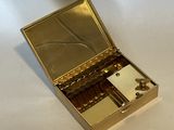 a small gold box with a mirror on top of it