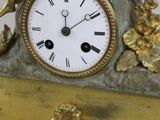 a gold clock with a statue of a woman sitting on top of it