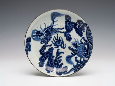 une assiette bleue et blanche ornée d'un motif représentant un dragon