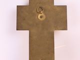 a metal cross on a white surface with a key in it
