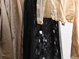 three dresses hanging on a clothes rack in a room