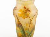 a vase with a yellow flower on it on a white surface