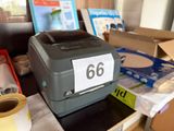 a printer sitting on top of a table next to a roll of tape