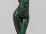statue of a woman with a hat on her head on a wooden table