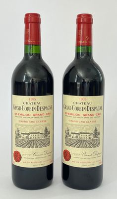 deux bouteilles de vin rouge posées l'une à côté de l'autre sur une surface blanche