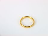 gros plan d'une bague en or sur une surface blanche