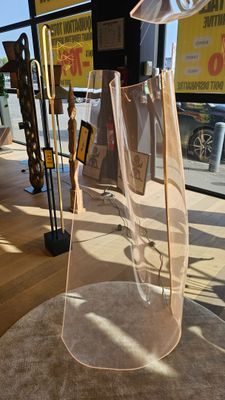 a clear glass vase with a metal handle on a table