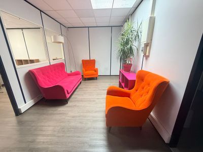 une pièce dans laquelle se trouvent un canapé, un fauteuil et un miroir