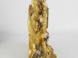 a gold figurine of a man and a woman on a bench