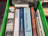 many books in a green box on a table