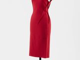une robe rouge posée sur un pied de mannequin, sur fond blanc