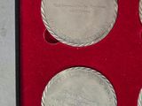 three silver coins in a red box on a white surface