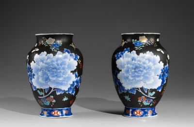 pair of vases with blue and white flowers on a black background