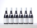 six bottles of red wine lined up in a row on a table