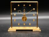 an image of a gold clock sitting on top of a table