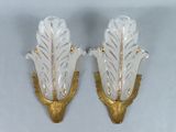 pair of gold and clear glass sconces with leaves on them