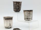 trois coupes en argent posées sur un socle transparent