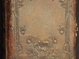 un vieux livre dont la couverture est ornée d'un motif floral