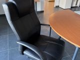 une chaise de bureau noire placée devant une table en bois