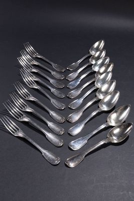 six cuillères en argent sont disposées en rangée sur une surface noire