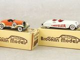 three small toy cars are sitting on top of a cardboard box