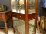 a glass display case in the corner of a room