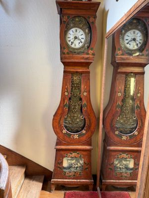 deux horloges de parquet placées l'une à côté de l'autre dans l'escalier
