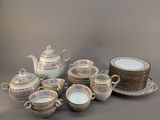 many plates and cups and a teapot on the table