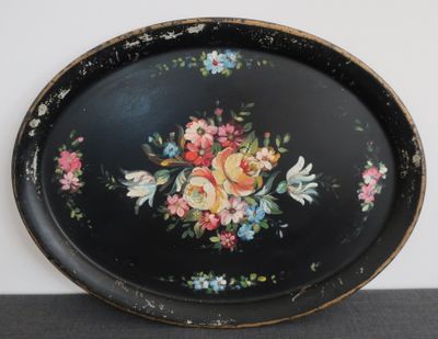 un plateau noir orné de fleurs, posé sur une table