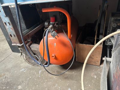 an orange air compressor sitting in the back of a truck