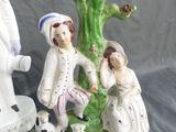 two figurines of people and a dog on a table