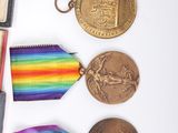 many medals and a book on a white table