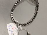 a silver bracelet with a blue stone on it and a tag attached to it
