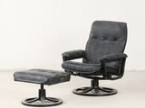 un fauteuil inclinable en cuir noir et un repose-pieds dans une pièce blanche