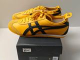yellow and black onitsuka sneakers on a box on a white surface