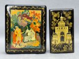 deux boîtes noires et dorées ornées de peintures, posées l'une à côté de l'autre